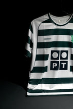 A Sporting Portugal soccer jersey with dark green and white horizontal stripes, featuring the PT logo on the front, displayed against a dark background.